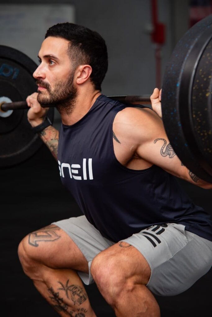 A man squatting with a barbell in his hands