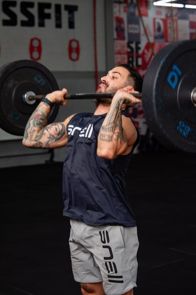 A man lifting a barbell in a gym